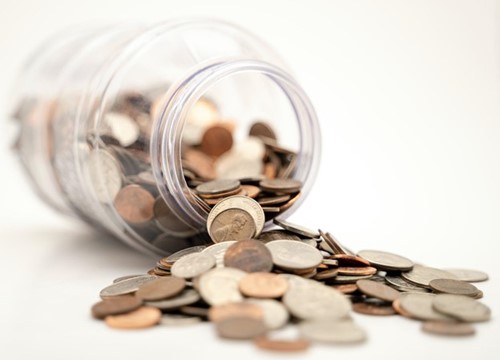 A jar full of change leaked onto a table